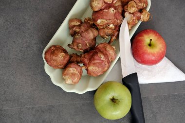 Bir tabak dolusu Kudüs enginarı, yeşil ve kırmızı elma. Diyet için önerilen yiyecekler.,