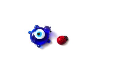 Uğur böceği ve uğursuz göz boncuğu beyaz bir arkaplanda, uğur böceğini kapat, nazar boncuğu ve şans.