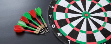 kırmızı, sarı, yeşil oklar ve dart tahtası, siyah arkaplanda