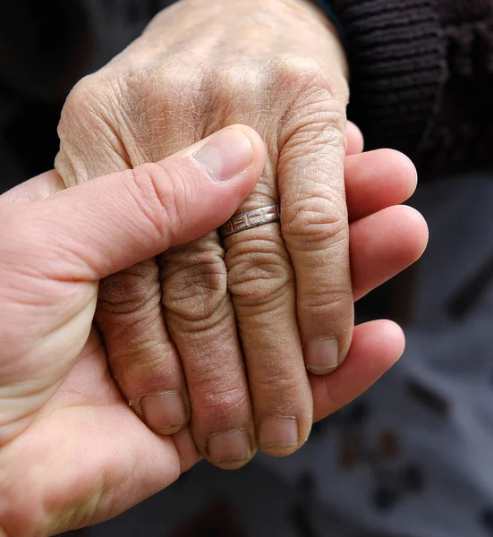 Joven Sostiene Tiernamente Mano Los Ancianos — Foto de Stock