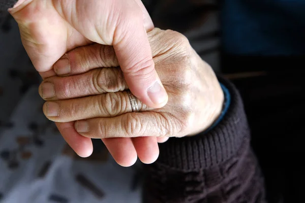 Joven Sostiene Tiernamente Mano Los Ancianos —  Fotos de Stock