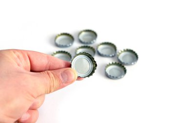 Beyaz zeminde kola ve soda kapağı, bir sürü soda şişesi.