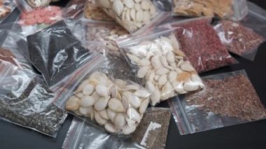 Siyah arka planda çeşitli organik olmayan tohumlarla paketlenerek bir tohum bankası oluşturuldu.,