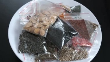 Siyah arka planda çeşitli organik olmayan tohumlarla paketlenerek bir tohum bankası oluşturuldu.,