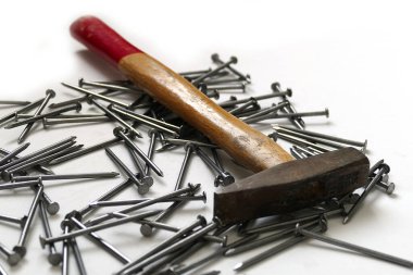 Beyaz arka planda çivi ve çekiç.,