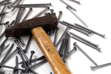 Beyaz arka planda çivi ve çekiç.,