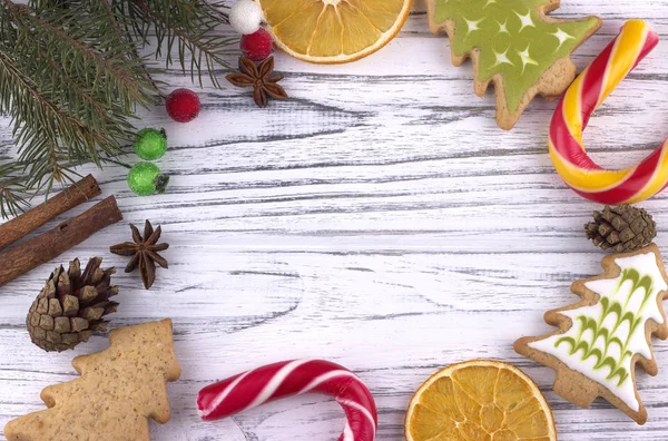 Navidad Navidad Navidad Año Nuevo Antecedentes con naranjas secas galletas estrella anís canela conos ramas de abeto natural bastón de caña en la mesa de madera blanca — Foto de Stock