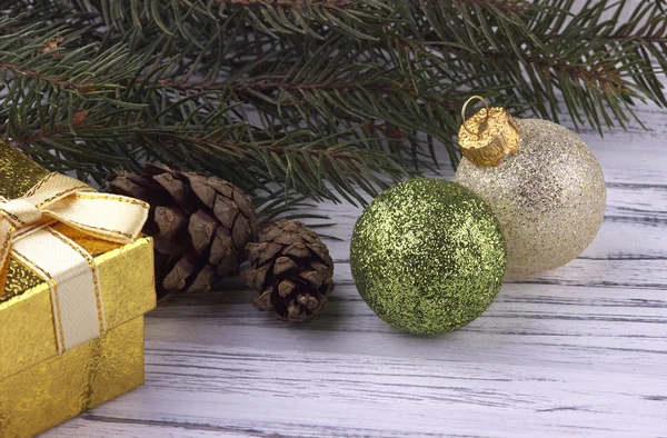 Beyaz ahşap arka plan üzerinde yeni yıl tatili arka plan ile altın Hediyelik kutu yeşil ve Gümüş Top doğal çam dalları Noel Xmas konisi — Stok fotoğraf
