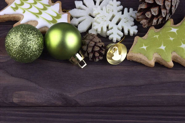 Navidad Navidad Navidad Año Nuevo Decoración con galletas de copos de nieve bolas de Navidad conos de abeto campana sobre fondo de madera oscura — Foto de Stock