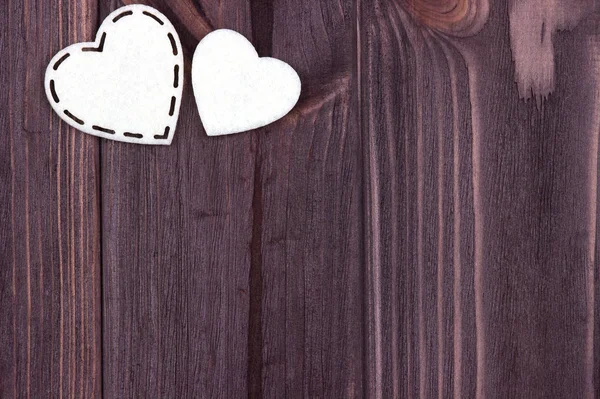 Dos corazones blancos de fieltro sobre un fondo de madera marrón. Día de San Valentín. Tarjeta de felicitación. Boda . — Foto de Stock