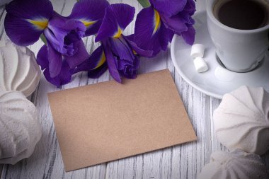 Natürmort ile örtmek kahve Kupası marshmallow Iris çiçek Beyaz ahşap zemin üzerinde. Düğün. Sevgililer günü kavramı.
