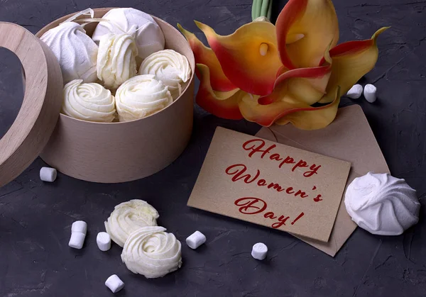 Bouquet of green yellow callas with marshmallows in a wooden round box on a gray wooden background lettering happy women's day english. — Stock Photo, Image