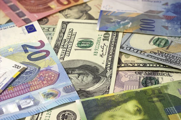 Geld achtergrond Amerikaanse dollars, euro en Zwitserse franc. — Stockfoto