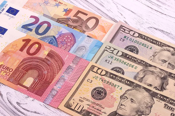 Geld achtergrond Amerikaanse dollars en euro verschillende denominationson oude witte houten plank. — Stockfoto