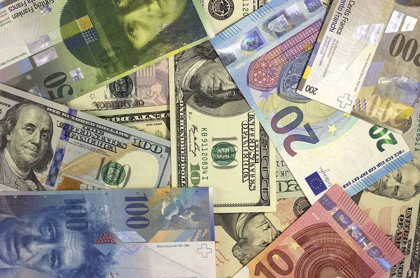 Geld achtergrond Amerikaanse dollars, euro en Zwitserse franc. — Stockfoto