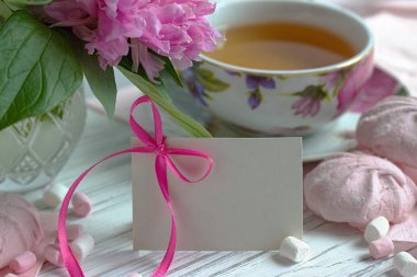 Peonies çiçek fincan çay tebrik kartı hatmi Beyaz ahşap zemin - stok görüntü üzerinde pembe.