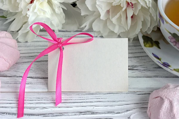 Peonies çiçek fincan çay tebrik kartı hatmi Beyaz ahşap zemin - stok görüntü üzerinde pembe.