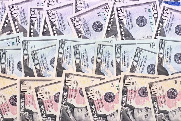 Abstrato dinheiro fundo nos dólares de diferentes denominações . — Fotografia de Stock