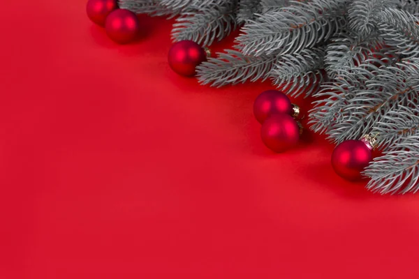 Рождественские елки и красные рождественские шары на красном фоне . — стоковое фото
