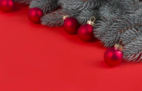 Рождественские елки и красные рождественские шары на красном фоне . — стоковое фото