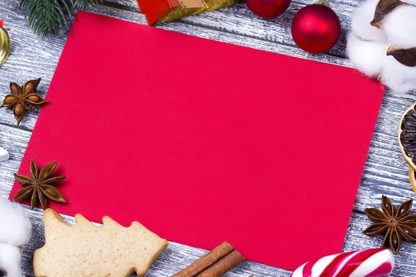Tarjeta de felicitación de Navidad roja con bastón de caramelo estrella naranja, fondo gris anís canela, ramas de abeto de madera, caja de regalo de bola . — Foto de Stock