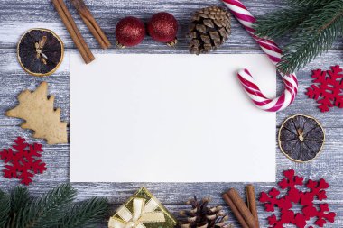 Noel dekorasyon tebrik kartı kırmızı kar taneleri turuncu şeker kamışı gri ahşap arka plan.