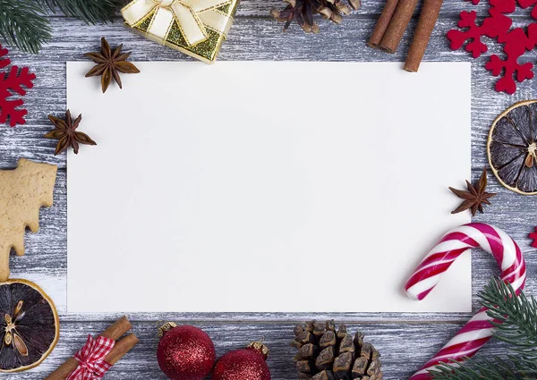 Navidad decoración tarjeta de felicitación rojo copos de nieve naranja caramelo, caña gris fondo de madera . — Foto de Stock