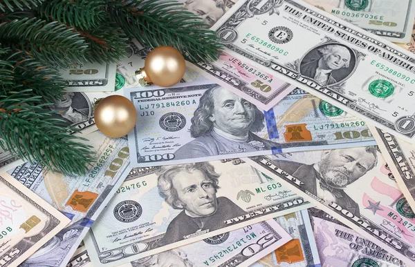Christmas tree branches golden balls on money background. — Stock Photo, Image
