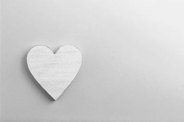 Coração de madeira branco sobre fundo de papelão preto e branco . — Fotografia de Stock