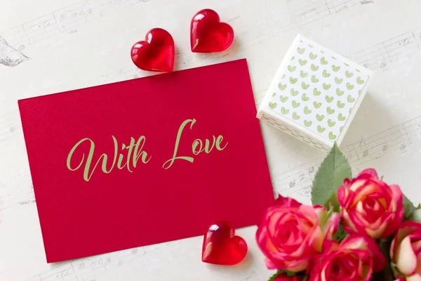 Tarjeta de felicitación del día de San Valentín con rosas caja de regalo corazones y letras con amor . — Foto de Stock