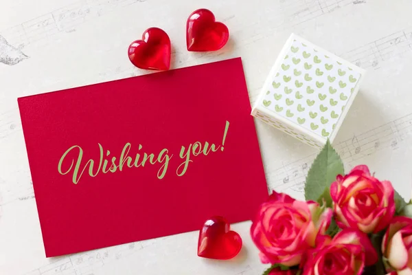 Tarjeta de felicitación del día de San Valentín con rosas caja de regalo corazones y letras que le desean . — Foto de Stock