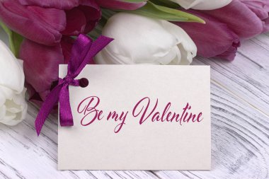 Sevgililer günü tebrik kartı, Lale mor kurdele, Beyaz ahşap arka plan beyaz..