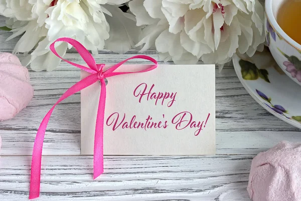 Valentinstag Grußkarte mit weißen Pfingstrosen Teetasse Marshmellow und Schriftzug. — Stockfoto