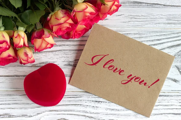 Tarjeta de felicitación del día de San Valentín con rosas caja de regalo roja y letras . — Foto de Stock