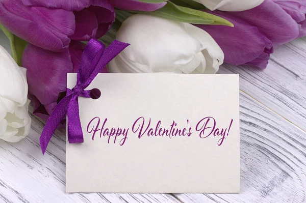 San Valentino biglietto di auguri, tulipani bianco nastro viola, sfondo in legno bianco . — Foto Stock