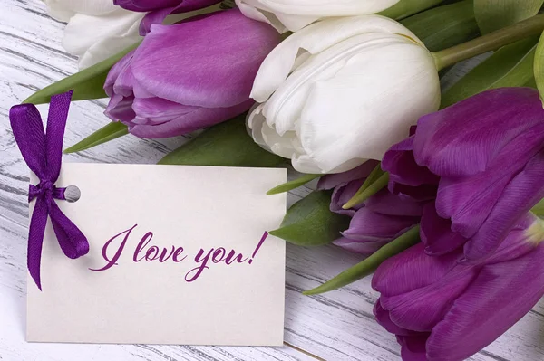 De kaart van de groet van de dag van Valentijnskaarten, tulpen wit paars lint, witte houten achtergrond. — Stockfoto