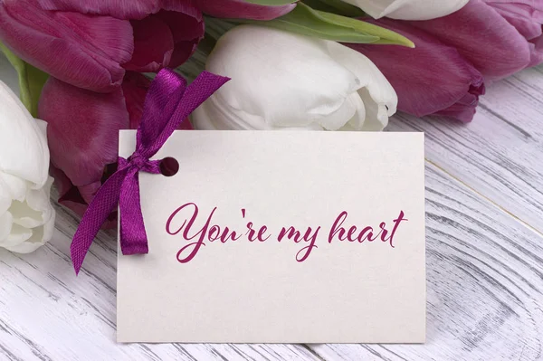 Tarjeta de felicitación del día de San Valentín, tulipanes cinta púrpura blanca, fondo de madera blanca . — Foto de Stock