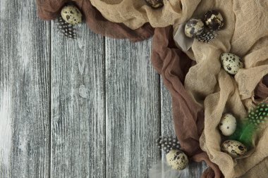 Bıldırcın yumurta bej kumaş gri ahşap arka plan ile Paskalya dekorasyon.