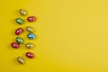 Çikolata Paskalya yumurtaları Sarı zemin üzerine folyo.