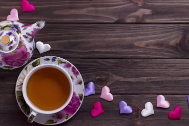 Demlik çay bardağı kahverengi ahşap masa üzerinde yürekleri.