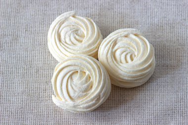 Beyaz masa örtüsü arka plan üzerinde üç beyaz zephyr.