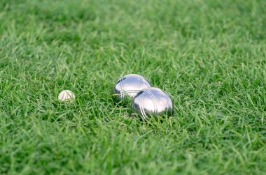 Close up of steel or metal boule balls on the green lawn clipart