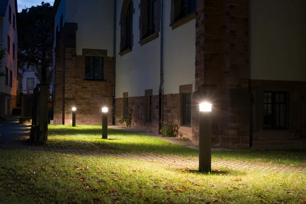 Outdoor lights (lanterns, bollards) in front of an old building at night — Stock Photo, Image