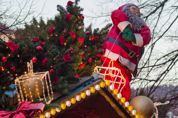 Noel baba figürü ve dekore edilmiş köknar ağacı Noel Pazar stand çatıda