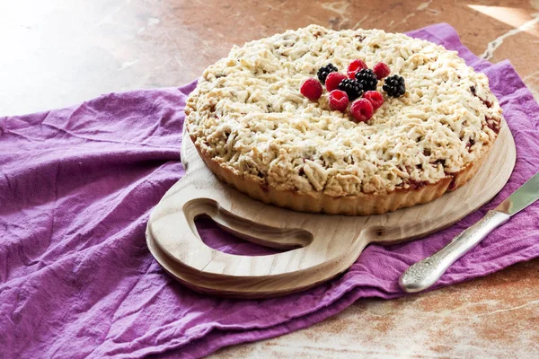 Домашний ягодный пирог с корочкой и крошкой на деревянной доске — стоковое фото