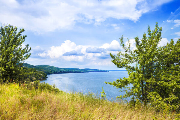 Beautiful landscape of Kaniv Reservoir shore, Ukraine, in sunny day with bright cloudy sky