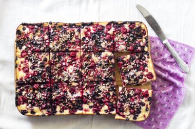 Çilekli lezzetli turta ve tahta bir tahtanın üzerinde dilimlenmiş süzme peynir. Düz yatış, üst görünüm