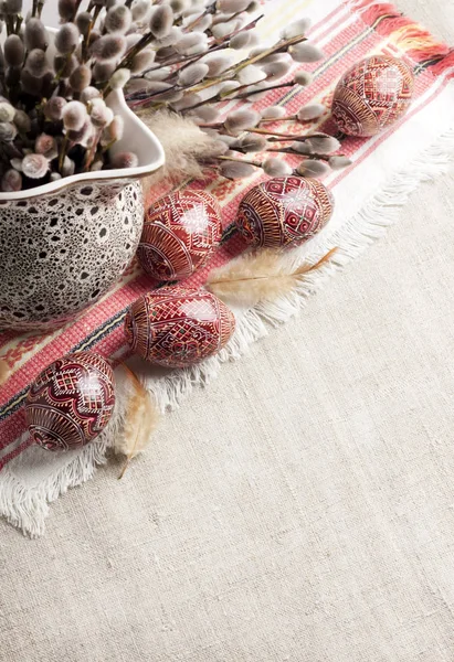 Pâques nature morte avec Pysanka et branches de saule dans une cruche en céramique sur un tissu ukrainien traditionnel. Œufs de Pâques décorés, traditionnels pour la culture de l'Europe de l'Est. Espace de copie — Photo