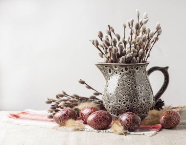 Pysanka ve söğüt dallarıyla geleneksel Ukrayna kumaşında seramik sürahi içinde Paskalya 'da hayat devam ediyor. Doğu Avrupa kültürü için geleneksel paskalya yumurtaları. Boşluğu kopyala