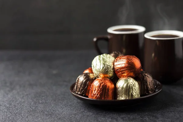 Шоколадні Цукерки Загорнуті Різнокольорову Фольгу Тарілці Дві Чашки Гарячої Кави — стокове фото